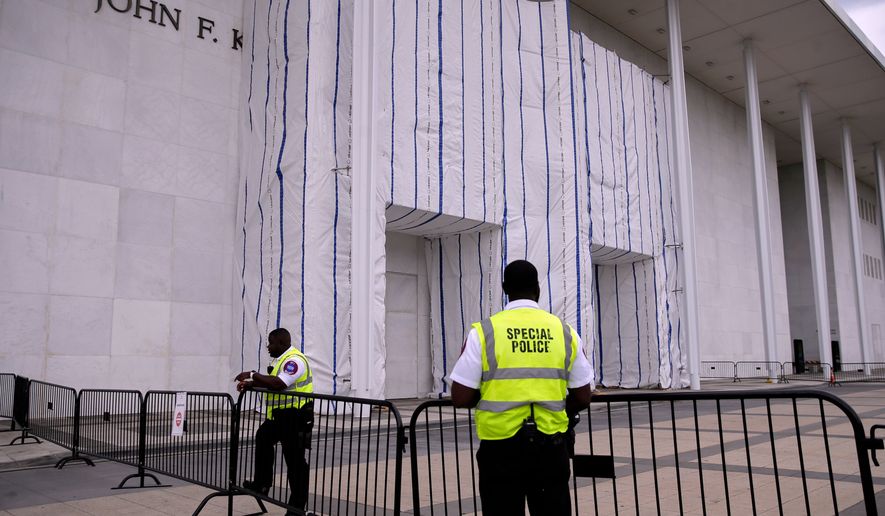 Special police are seen near the John F. Kennedy Center for the Performing Arts, as it's sign remains covered by a tarp, Thursday, June 18, 2026, in Washington. (AP Photo/Rahmat Gul)
