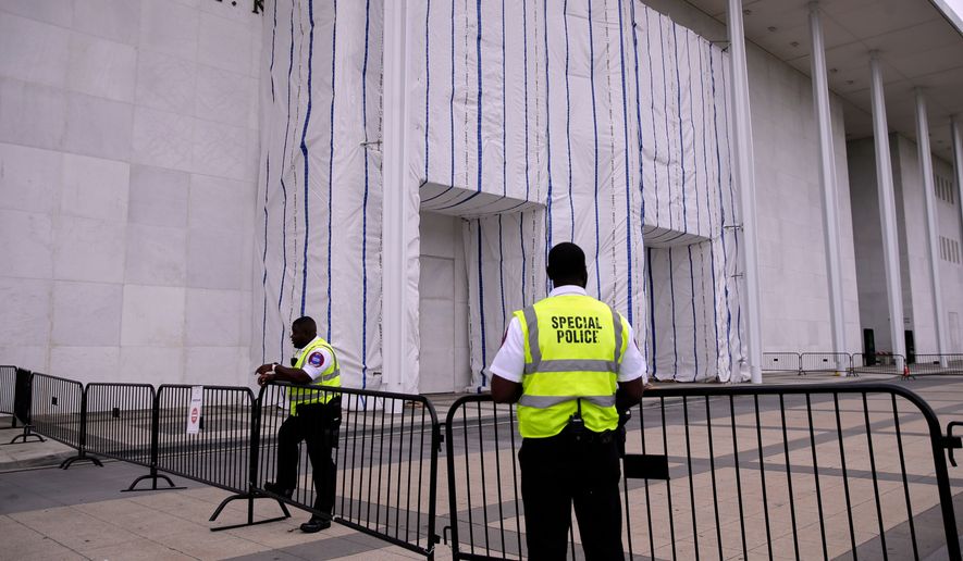 Special police are seen near the John F. Kennedy Center for the Performing Arts, as its sign remains covered by a tarp, Thursday, June 18, 2026, in Washington. (AP Photo/Rahmat Gul)