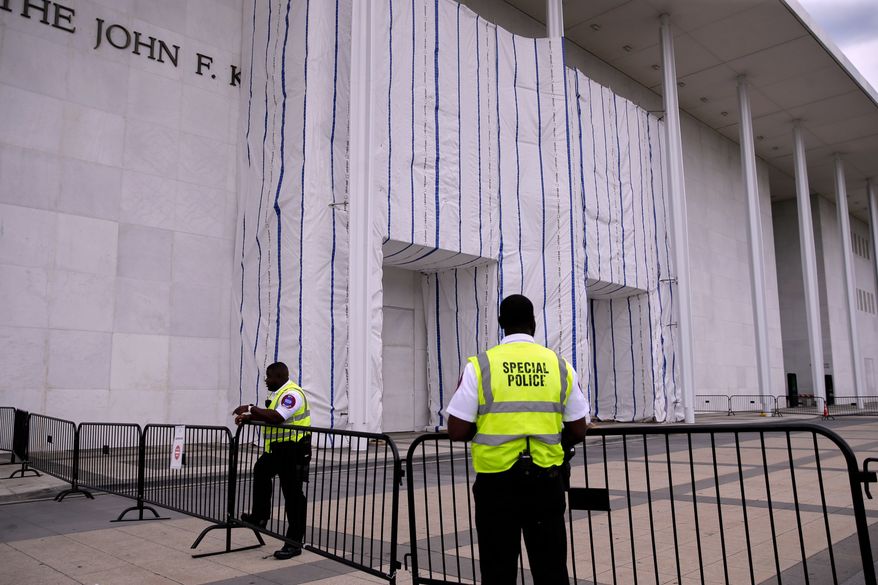 Special police are seen near the John F. Kennedy Center for the Performing Arts, as it's sign remains covered by a tarp, Thursday, June 18, 2026, in Washington. (AP Photo/Rahmat Gul)