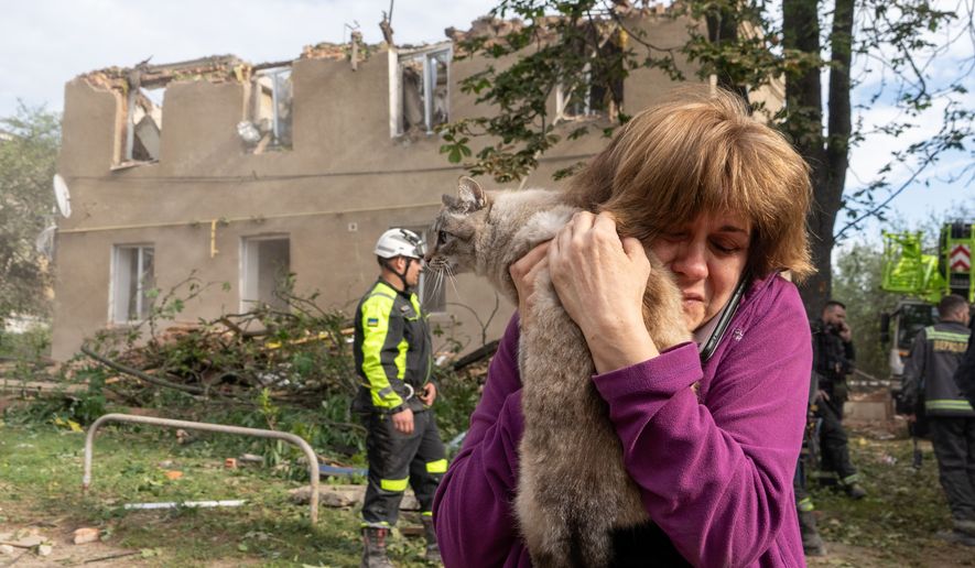 A woman holds her cat after it being found during search and rescue works in the damaged residential building following Russia's missile attack in Kharkiv, Ukraine, Saturday, June 20, 2026. (AP Photo/Andrii Marienko)
