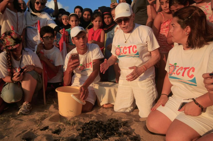 Mona Khalil, a Lebanese conservationist who died on Friday after being wounded in an Israeli strike on her home on Lebanon's southern coast, releases baby sea turtles in Mansouri village near Tyre city, south Lebanon, July 29, 2018. (AP Photo/Hussein Malla)
