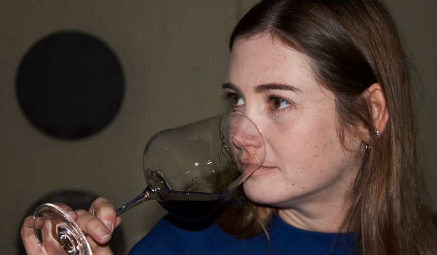 Natasha Jacka evaluates a glass of wine during the period it matures in oak in Cape Town, South Africa, Thursday, June 4, 2026. (AP Photo/Neil Shaw)