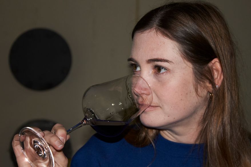 Natasha Jacka evaluates a glass of wine during the period it matures in oak in Cape Town, South Africa, Thursday, June 4, 2026. (AP Photo/Neil Shaw)