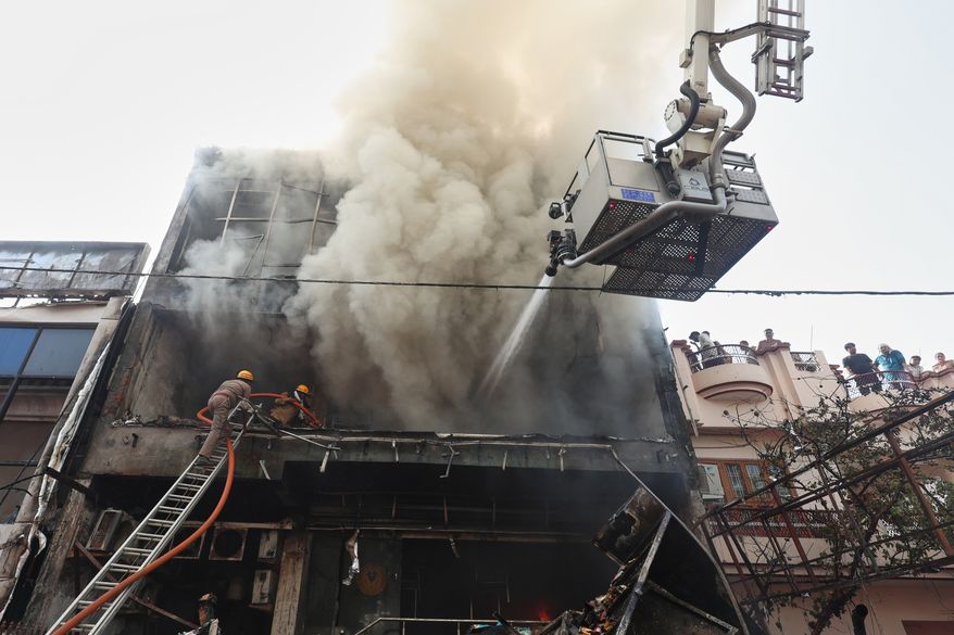 Firefighters work to put out a fire that broke out at a study center in Lucknow, India, Monday, June 22, 2026. (AP Photo/Sumit Kumar)