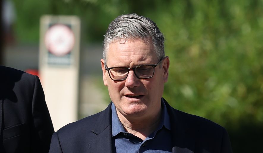 Britain's Prime Minister Keir Starmer walks, as he visits a housing development in north London, Friday, June 19, 2026. (Peter Macdiarmid/Pool Photo via AP)