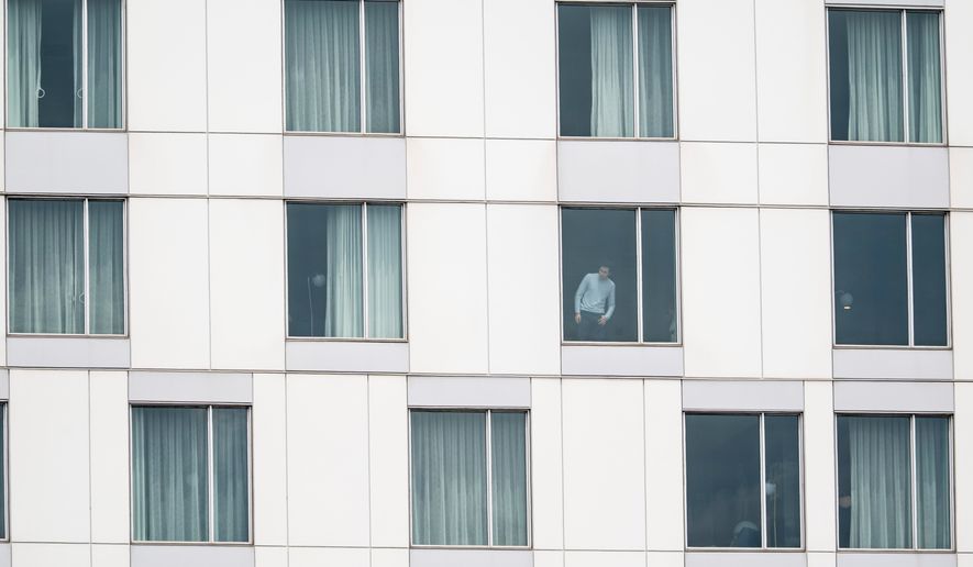 A person looks out of a hotel window at the scene of a shooting in Montreal on Monday, June 22, 2026. (Christopher Katsarov/The Canadian Press via AP)