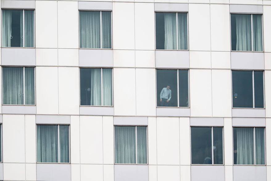 A person looks out of a hotel window at the scene of a shooting in Montreal on Monday, June 22, 2026. (Christopher Katsarov/The Canadian Press via AP)