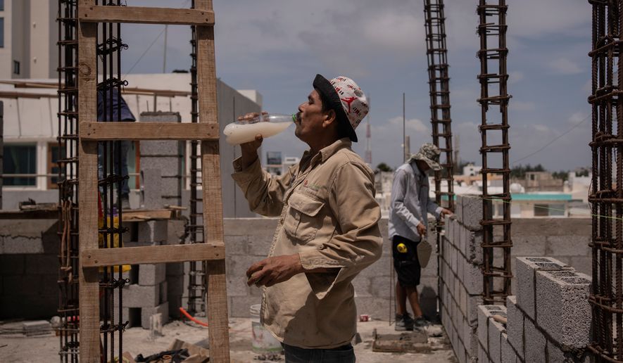 FILE - Jorge Moreno, a worker, drinks flavored water to cope with the heat wave during his workday at a construction site in Veracruz, Mexico, on June 17, 2024. (AP Photo/Felix Marquez, File)
