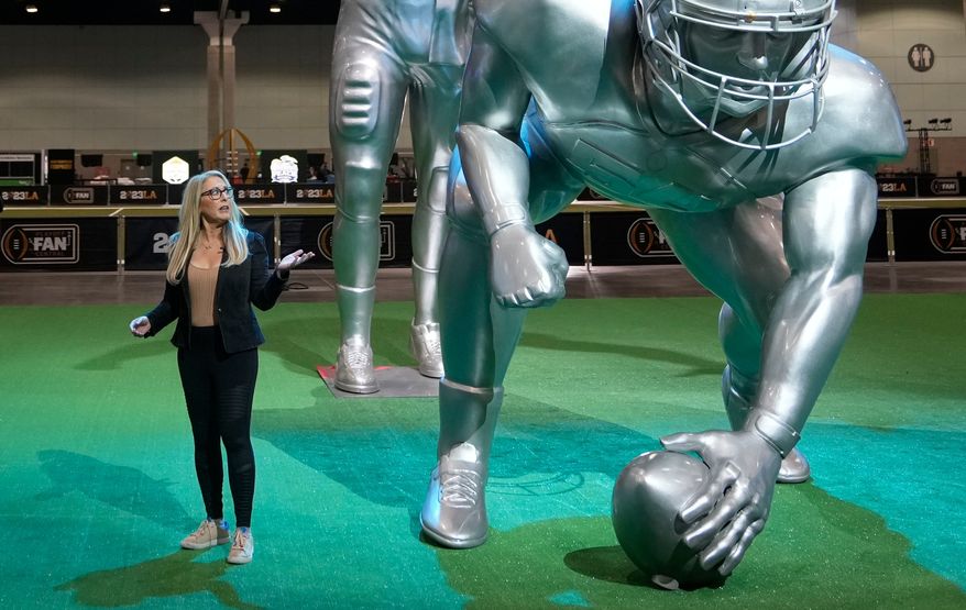 FILE - ESPN anchor Linda Cohn reports next to large images of football players at a fan fest Thursday, Jan. 5, 2023, at the Los Angeles Convention Center in Los Angeles. (AP Photo/Marcio Sanchez, File)