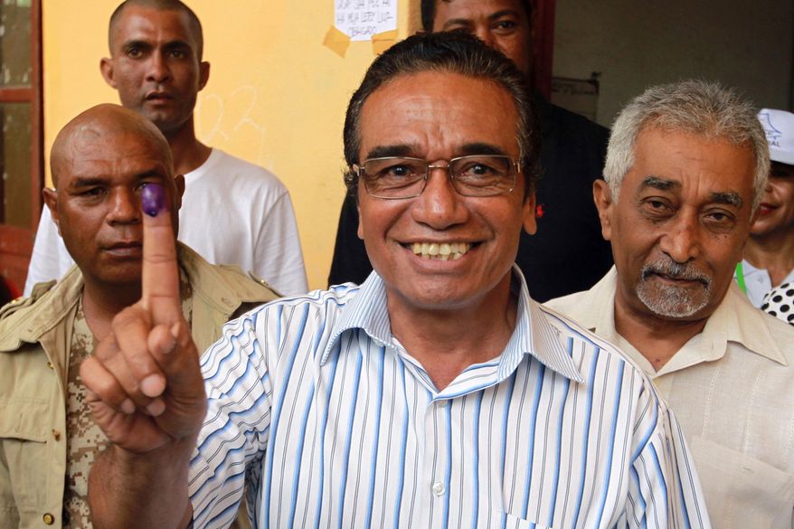 FILE - Fretilin Party leader Francisco "Lu Olo" Guterres, center, shows his inked finger after giving his vote during the presidential election at a polling station in Dili, East Timor, on March 20, 2017. (AP Photo/Kandhi Barnez, File)