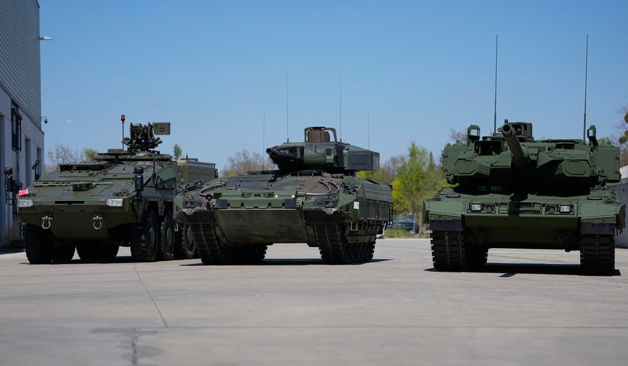 FILE - A boxer armoured personnel carrier, from left, a Puma infantry fighting vehicle and a Leopard battle tank are displayed during the opening of a new production line production line of Boxer 8x8 wheeled armoured personnel carrier produced by pan-European defense company KNDS in Munich, Germany, on April 22, 2026. (AP Photo/Matthias Schrader, File)