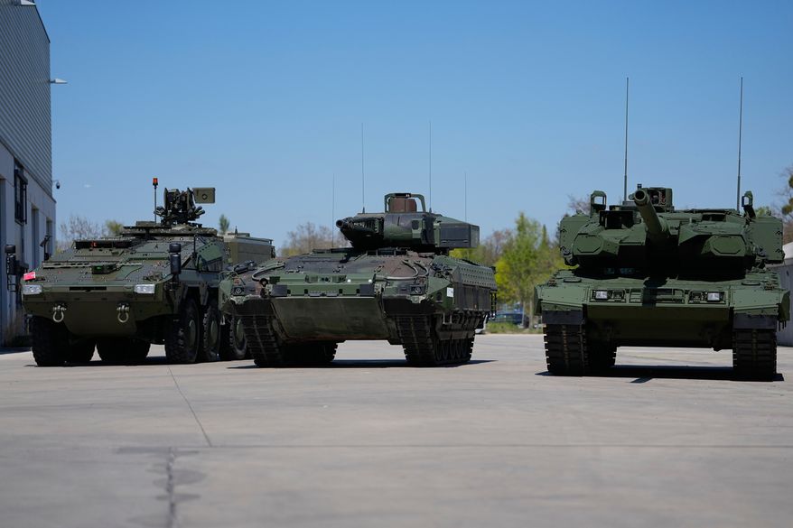 FILE - A boxer armoured personnel carrier, from left, a Puma infantry fighting vehicle and a Leopard battle tank are displayed during the opening of a new production line production line of Boxer 8x8 wheeled armoured personnel carrier produced by pan-European defense company KNDS in Munich, Germany, on April 22, 2026. (AP Photo/Matthias Schrader, File)
