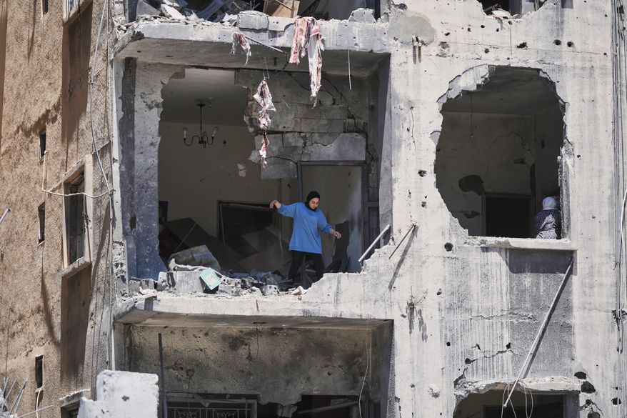 A woman walks through her apartment damaged in Israeli strikes in the southern port city of Tyre, Lebanon, Thursday, June 18, 2026. (AP Photo/Hassan Ammar)