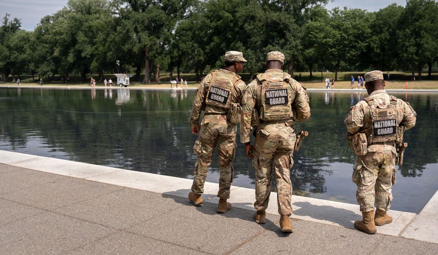 National Guard members look at the Lincoln Memorial Reflecting Pool, Monday, June 22, 2026, in Washington. (AP Photo/Mark Schiefelbein)