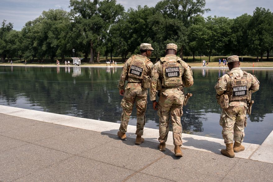 National Guard members look at the Lincoln Memorial Reflecting Pool, Monday, June 22, 2026, in Washington. (AP Photo/Mark Schiefelbein)