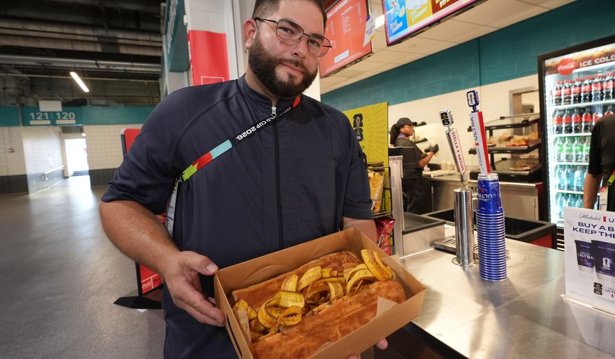 Lazaro Luya, the concession chef at Sol Cubano, displays their special, pan with lechon and fresh mariquitas at Miami Stadium Sunday, June 21, 2026, in Miami Gardens, Fla. (AP Photo/Marta Lavandier)