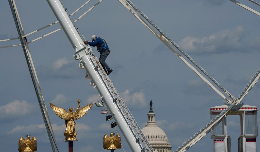 The U.S. Capitol is seen in the background of the ferris wheel as preparation continues for the Great American State Fair on the National Mall, Sunday, June 21, 2026, in Washington. (AP Photo/Jon Elswick