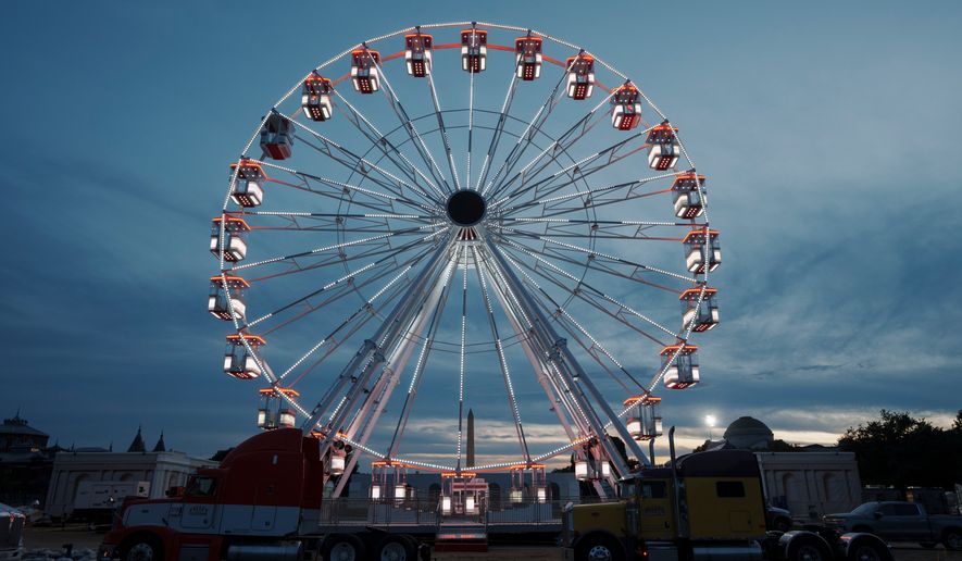 The ferris wheel on the National Mall is lit as preparation continues for the Great American State Fair on the National Mall, Sunday, June 21, 2026, in Washington. (AP Photo/Jon Elswick