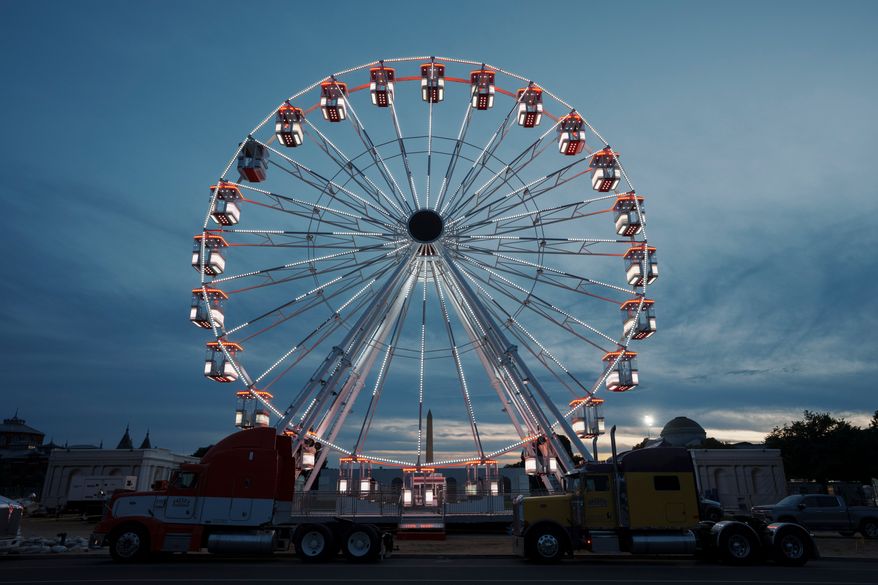 The ferris wheel on the National Mall is lit as preparation continues for the Great American State Fair on the National Mall, Sunday, June 21, 2026, in Washington. (AP Photo/Jon Elswick