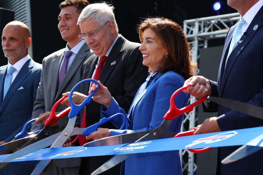 Buffalo Bills owner Terry Pegula, third from left, and New York Gov. Kathy Hochul, right, participate in the ribbon cutting ceremony at new Bills Highmark Stadium in Orchard Park, N.Y., Tuesday, June 23, 2026. (AP Photo/Jeffrey T. Barnes)