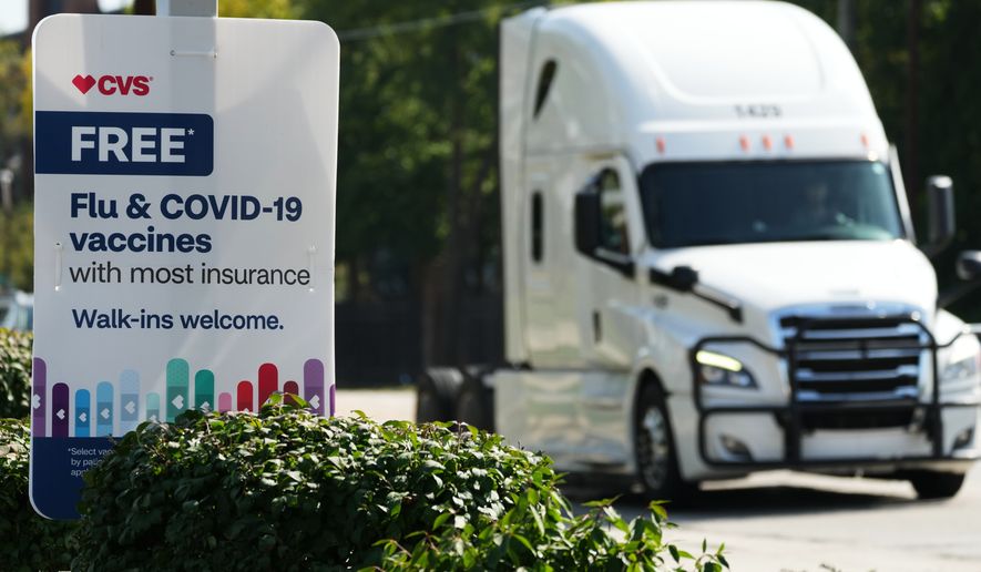 FILE - A sign for flu & COVID-19 vaccines is displayed outside a CVS store in Buffalo Grove, Ill., Sept. 23, 2025. (AP Photo/Nam Y. Huh, file)