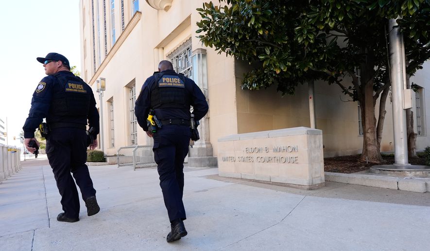 FILE - Officers with the Department of Homeland Security walk on the sidewalk outside the Eldon B. Mahon U.S. Courthouse during a trial for people connected to a 2025 shooting outside an ICE detention facility, in Fort Worth, Texas, March 12, 2026. (AP Photo/Tony Gutierrez, File)