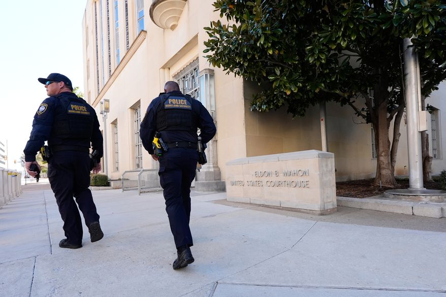 FILE - Officers with the Department of Homeland Security walk on the sidewalk outside the Eldon B. Mahon U.S. Courthouse during a trial for people connected to a 2025 shooting outside an ICE detention facility, in Fort Worth, Texas, March 12, 2026. (AP Photo/Tony Gutierrez, File)