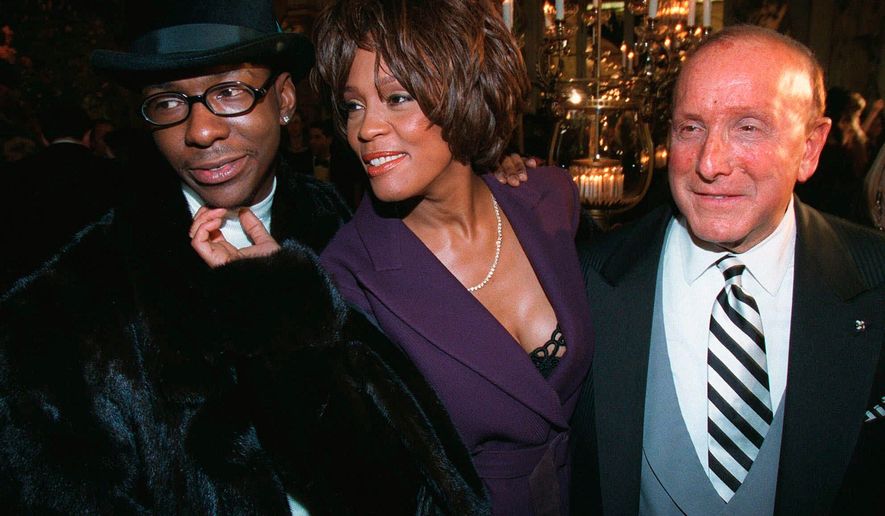 Bobby Brown, left, and Whitney Houston appear with music producer Clive Davis, right, at a pre-Grammy party in New York on Feb. 24, 1998. (AP Photo/Stuart Ramson, File)