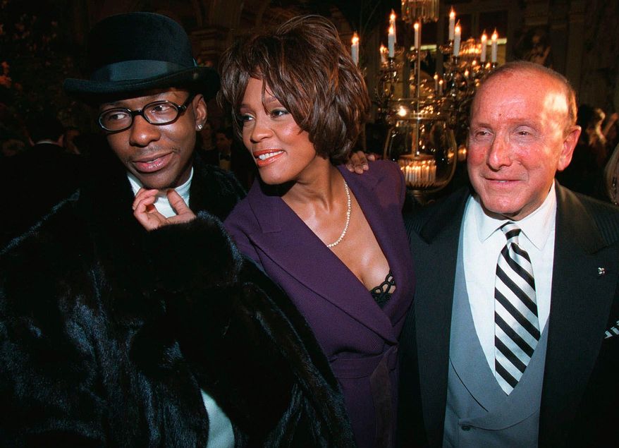 Bobby Brown, left, and Whitney Houston appear with music producer Clive Davis, right, at a pre-Grammy party in New York on Feb. 24, 1998. (AP Photo/Stuart Ramson, File)