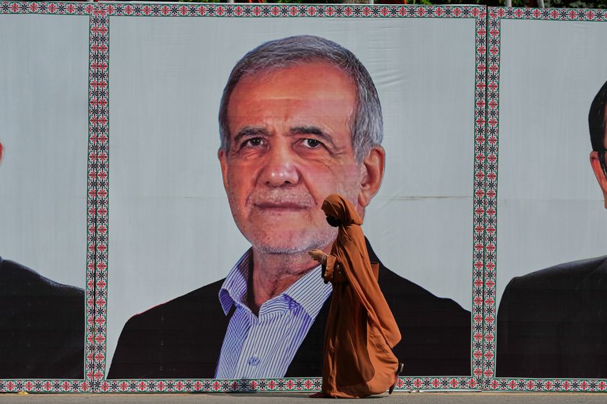 A woman walks past a welcoming billboard featuring Iranian President Masoud Pezeshkian along a roadside in Islamabad, Pakistan, Tuesday, June 23, 2026. (AP Photo/Anjum Naveed)