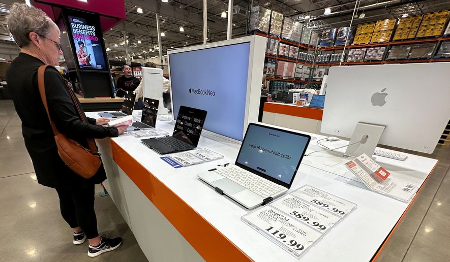 A shopper looks over Apple MacBook laptops on display in a Costco warehouse on June 2, 2026, in Sheridan, Colo. (AP Photo/David Zalubowski, File)