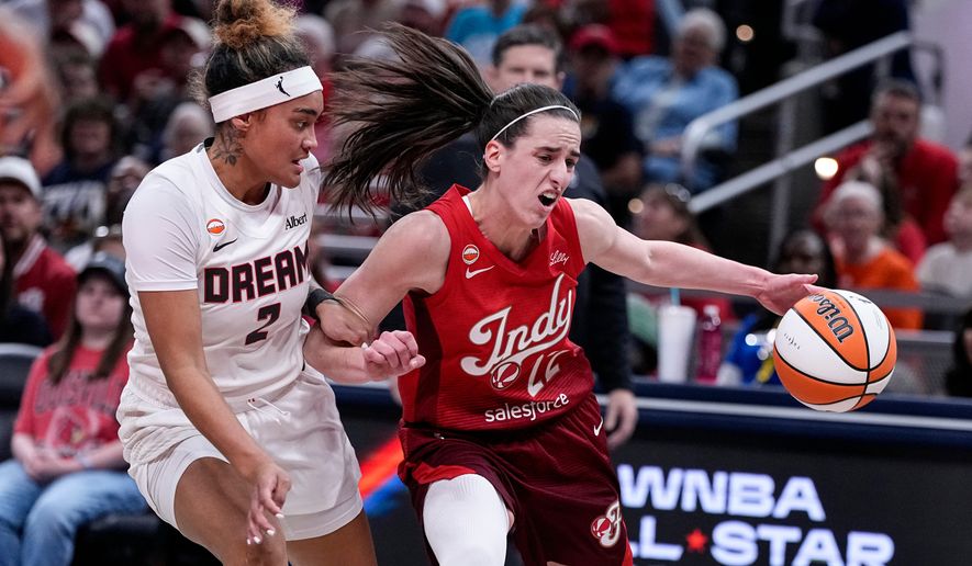 Indiana Fever guard Caitlin Clark (22) drives on Atlanta Dream guard Te-Hina Paopao (2) in the first half of a WNBA basketball game in Indianapolis, Thursday, June 18, 2026. (AP Photo/Michael Conroy)