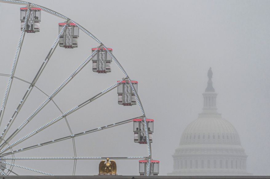 The U.S. Capitol is seen through fog behind the ferris wheel at the Great American State Fair on the National Mall, Sunday June 28, 2026, in Washington. (AP Photo/Jen Golbeck)