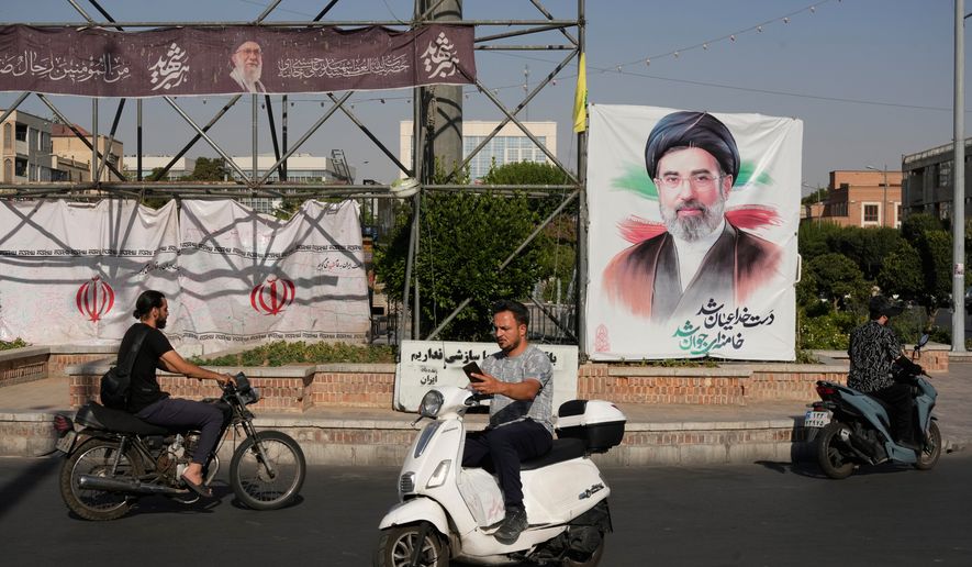 Motorbikes drive past a banner showing a portrait of the Iranian Supreme Leader Ayatollah Mojtaba Khamenei in downtown Tehran, Iran, Monday, June 29, 2026. (AP Photo/Vahid Salemi)