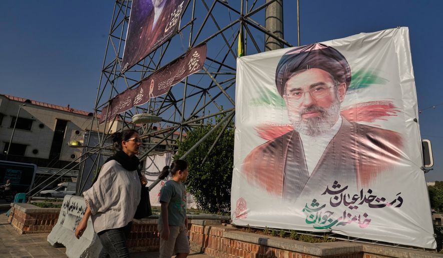 People walk past banners showing portraits of the Iranian Supreme Leader Ayatollah Mojtaba Khamenei in downtown Tehran, Iran, Monday, June 29, 2026. (AP Photo/Vahid Salemi)