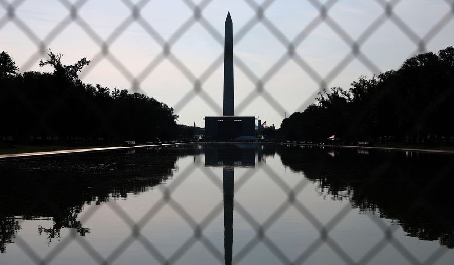 The Washington Monument, reflected in the Lincoln Memorial Reflecting Pool, is seen behind fencing, Tuesday, June 30, 2026, in Washington. (AP Photo/Rahmat Gul)