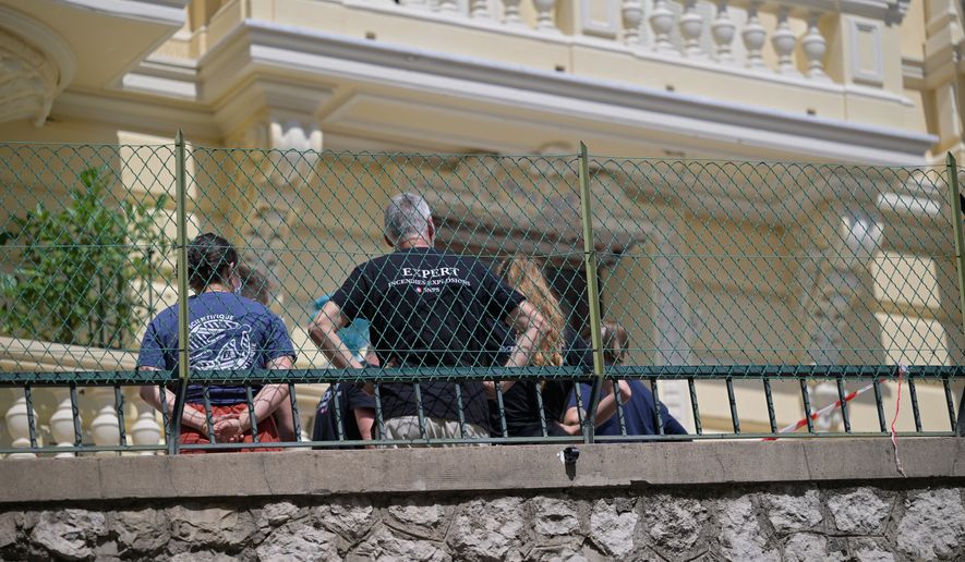 Investigators examine the scene at the residential building where an explosive device seriously injured three people a day earlier in Monaco, Tuesday, June 30, 2026. (AP Photo/Philippe Magoni)