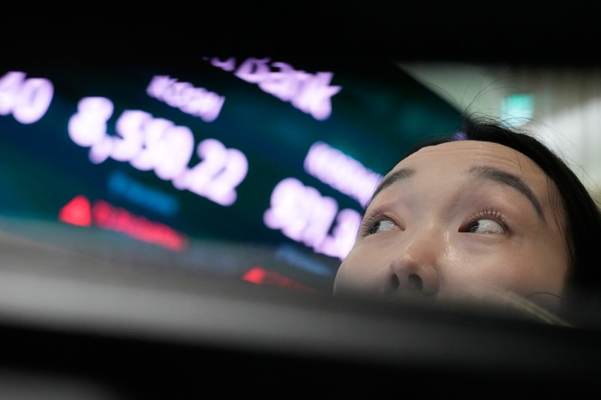 A currency trader watches monitors near a screen showing the Korea Composite Stock Price Index (KOSPI) at the foreign exchange dealing room of the Hana Bank headquarters in Seoul, South Korea, Wednesday, July 1, 2026. (AP Photo/Ahn Young-joon)