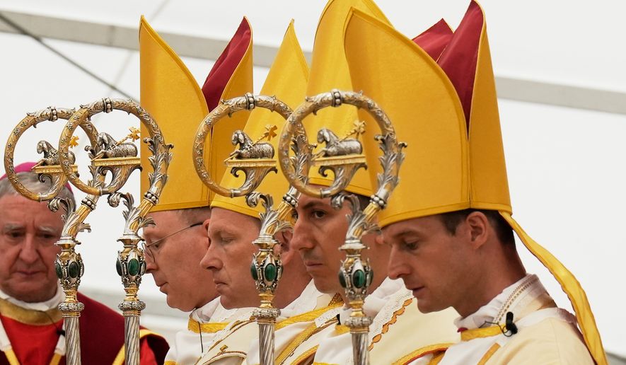 Newly consecrated Bishops, from left, Pascal Schreiber, Michael Goldade, Michel Poinsinet de Sivry and Marc Hanappier, wearing their miters and holding their pastoral staffs, pray at the end of their consecration ceremony in a tent set up outside the Society of St. Pius X seminary in Econe, Switzerland, Wednesday, July 1, 2026. (AP Photo/Baz Ratner)