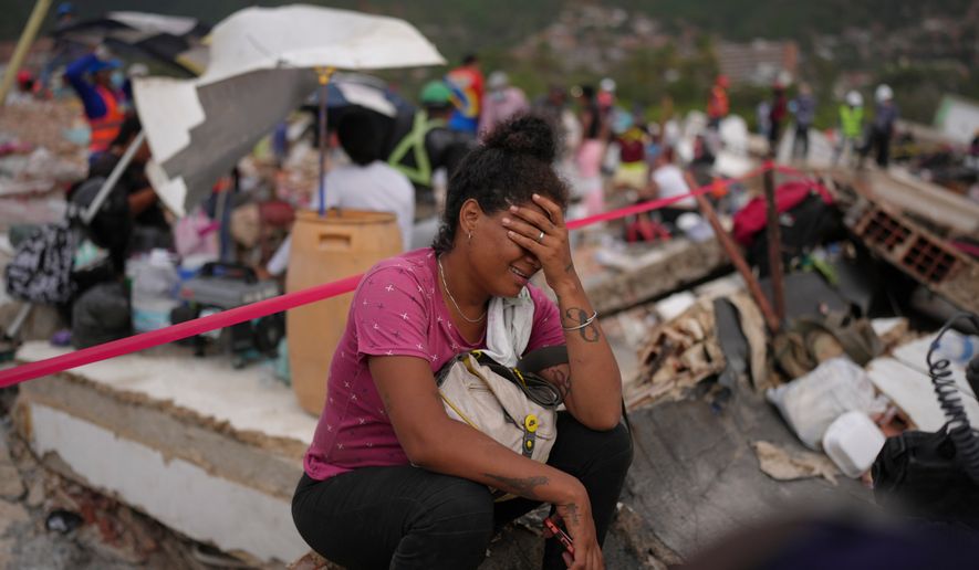 Khaterine Roa cries as members of the Los Angeles County Fire Department search for survivors at a building that collapsed during the earthquakes that struck La Guaira, Venezuela, Tuesday, June 30, 2026. (AP Photo/Matias Delacroix)