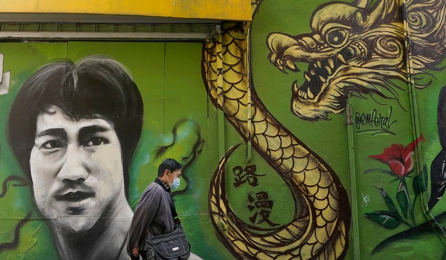 A man walks past a mural showing Bruce Lee and a dragon in San Francisco, Dec. 30, 2020. (AP Photo/Jeff Chiu, File)