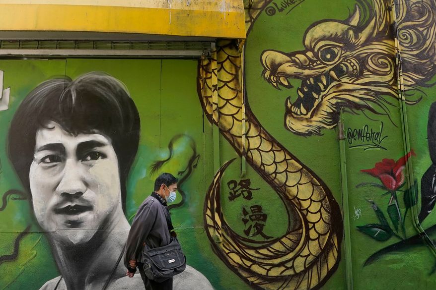 A man walks past a mural showing Bruce Lee and a dragon in San Francisco, Dec. 30, 2020. (AP Photo/Jeff Chiu, File)