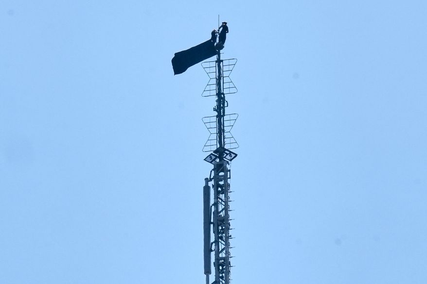 A person is shown atop the spire of the Empire State Building, in New York, Wednesday, July 1, 2026. (AP Photo/Richard Drew)