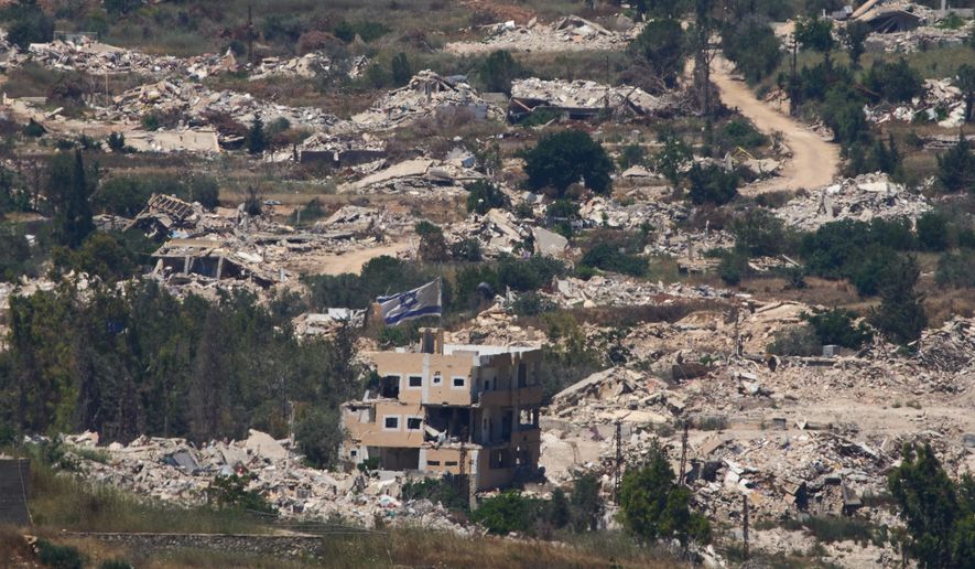 An Israeli flag hangs on a damaged building in southern Lebanon as seen from northern Israel, Wednesday, July 1, 2026. (AP Photo/Ariel Schalit)