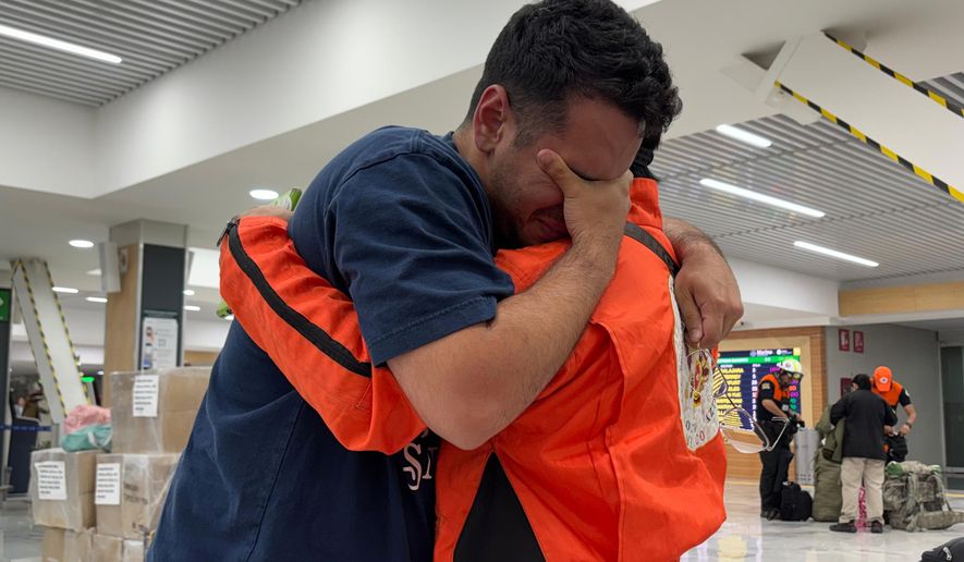 German Bello, right, a volunteer with the Mexican search-and-rescue brigade Los Topos Azteca, embraces a Venezuelan man who approached the team to thank them as they departed for Venezuela from Mexico City's airport, Tuesday, June 30, 2026. (AP Photo/Fernanda Pesce)