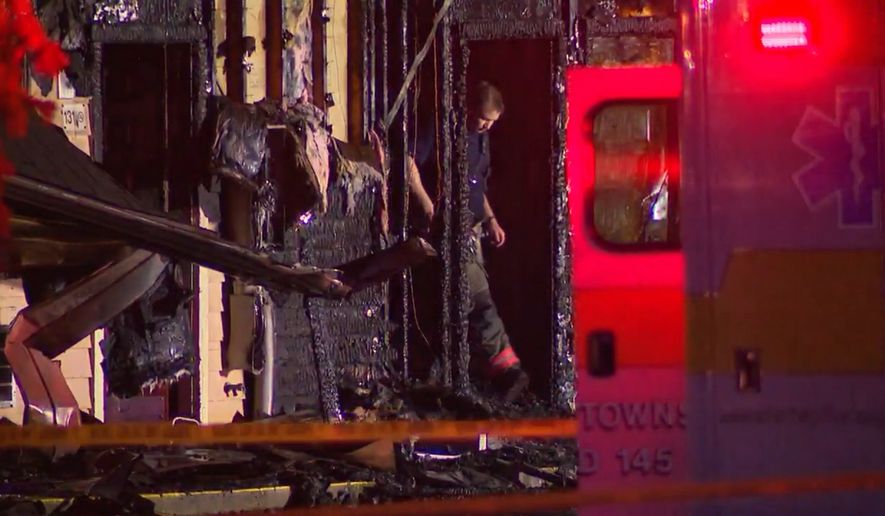 In this photo, taken from video, a firefighter exits the charred remains of an Econo Lodge motel in Wooster, Ohio, where three people died in a blaze early Wednesday, July 1, 2026. (WEWS/via AP)