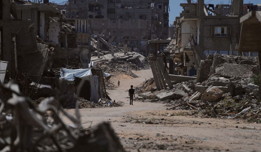 A Palestinian child walks along a street surrounded by buildings destroyed in Israeli military strikes during the Israel-Hamas war in Khan Younis, Gaza Strip, Wednesday, July 1, 2026. (AP Photo/Abdel Kareem Hana)