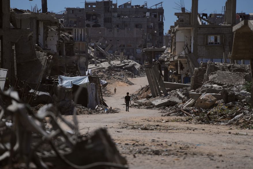 A Palestinian child walks along a street surrounded by buildings destroyed in Israeli military strikes during the Israel-Hamas war in Khan Younis, Gaza Strip, Wednesday, July 1, 2026. (AP Photo/Abdel Kareem Hana)