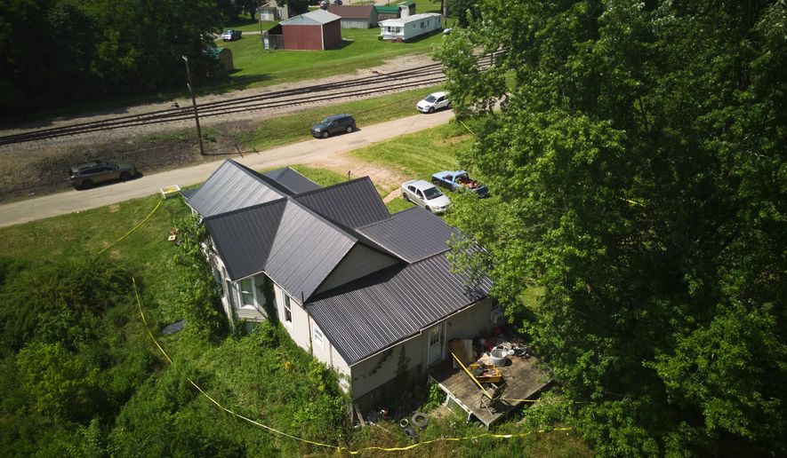 Police tape surrounds a home where authorities say they removed 16 children and arrested four adults in Hamden, Ohio, Wednesday, July 1, 2026. (AP Photo/Carolyn Kaster)