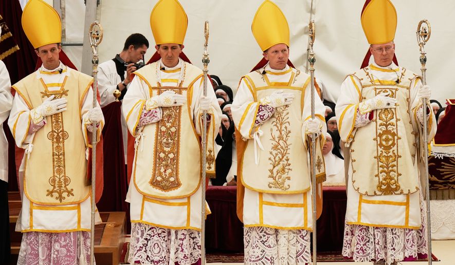 Newly consecrated Bishops, from left, Marc Hanappier, Michel Poinsinet de Sivry, Michael Goldade and Pascal Schreiber wearing their miters and holding their pastoral staffs, stand at the end of their consecration ceremony in a tent set up outside the Society of St. Pius X seminary in Econe, Switzerland, Wednesday, July 1, 2026. (AP Photo/Baz Ratner)